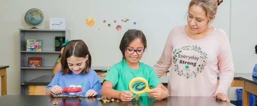 Girls with microscope for Volunteer Essentials Girls_microscope_Volunteer_Essentials