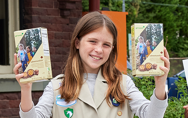 Girl holding up two cookie boxes