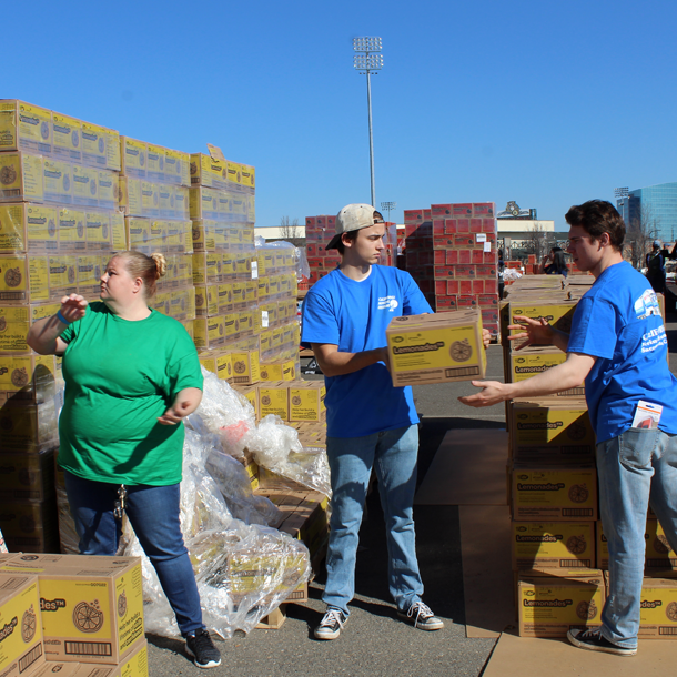 three volunteers moving cases of cookies