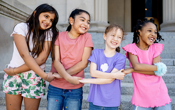 Three Girl Scout Brownies with their arms around each other