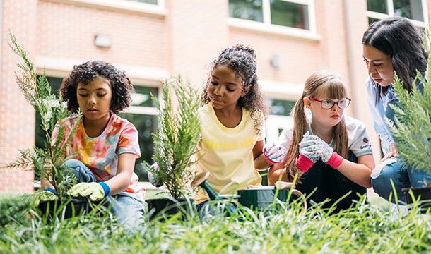 Three girls planting trees